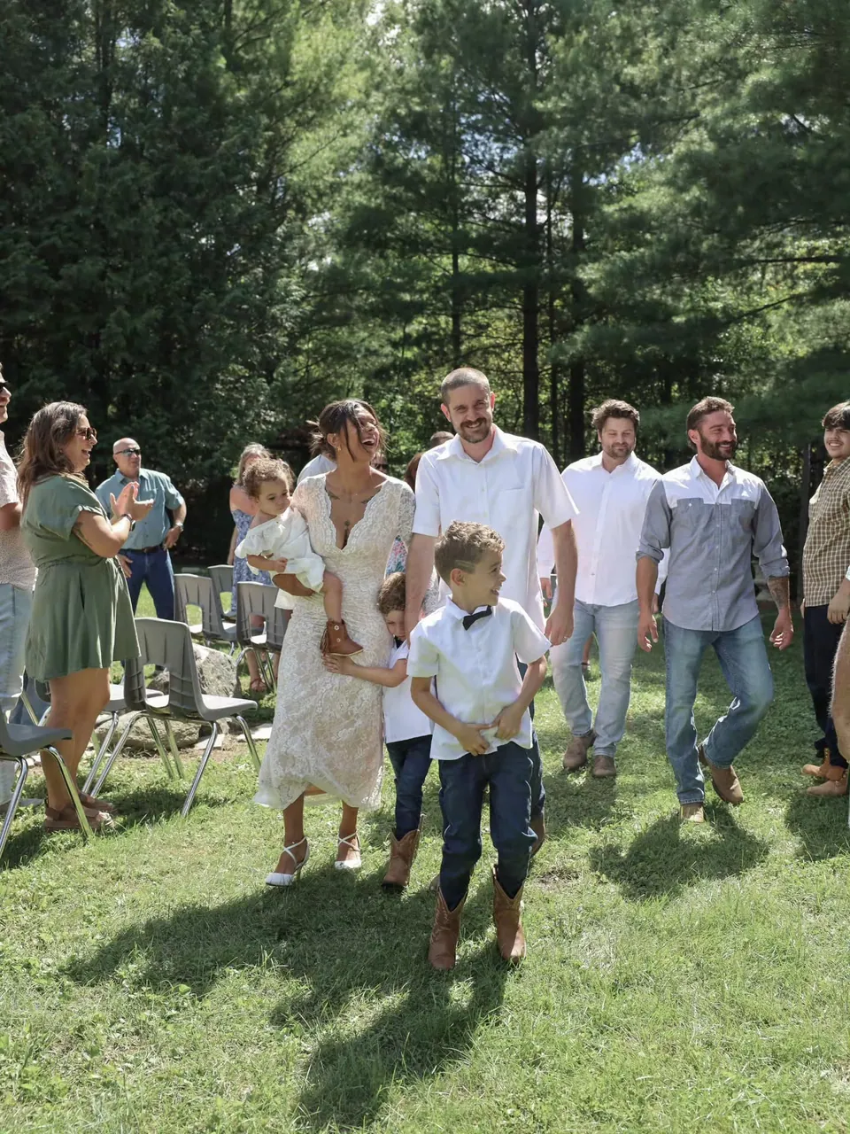 Wedding guests gathered on a wooded lawn