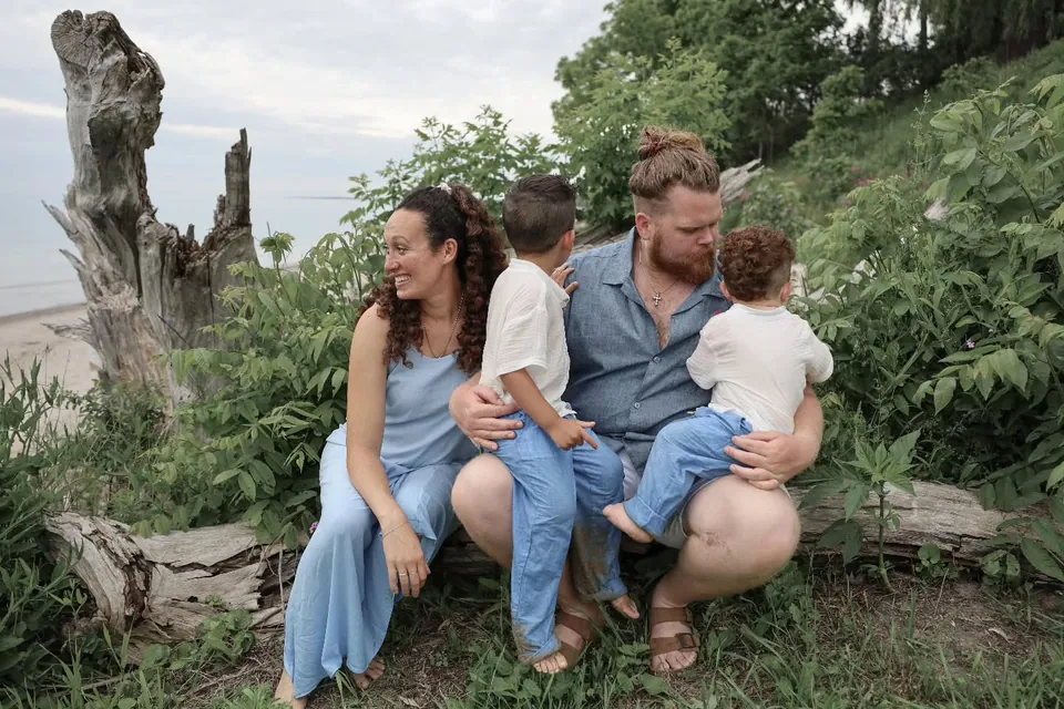 A family of four on a rocky shoreline